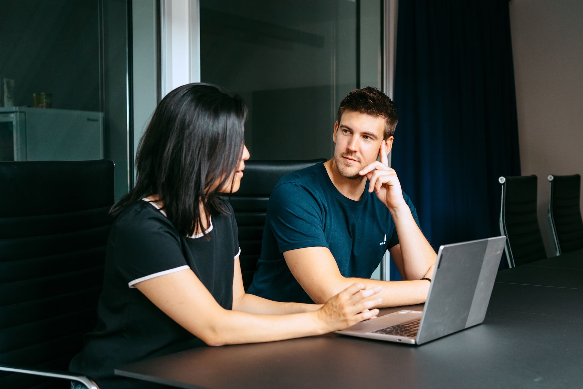 Business mentor guiding a learner through a program on a laptop